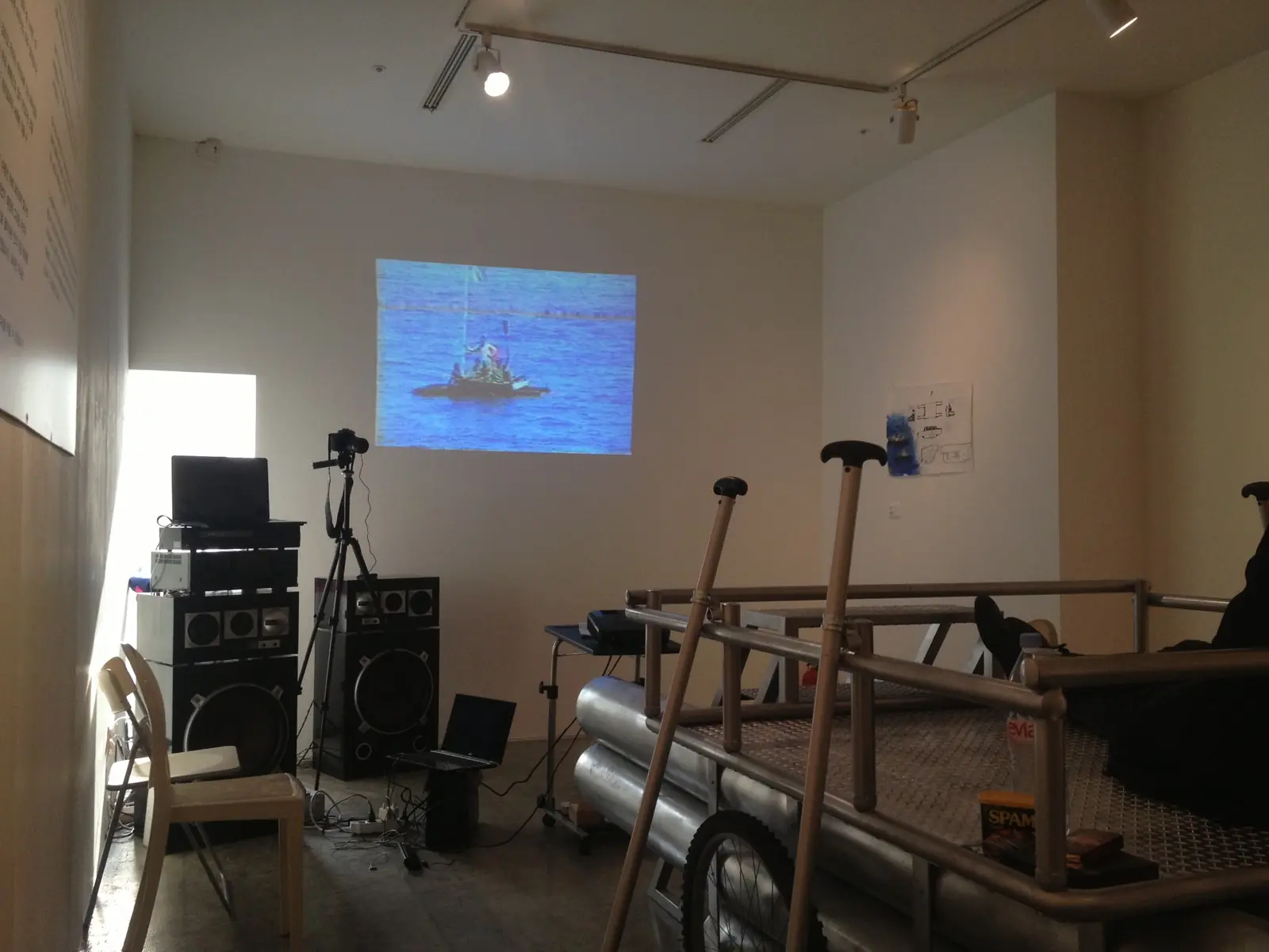 Installation view with the raft installation and the video documenting the 1993 voyage and rescue positioned facing one another.